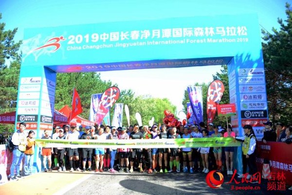 A man crosses the finish line during the 2019 China Changchun Jingyuetan International Forest Marathon on June 16. 