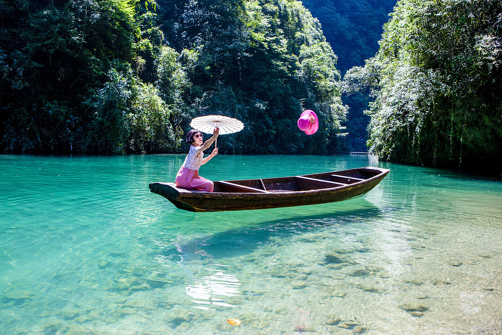 Tourists enjoy floating on crystal-clear water at Pingshan Canyon