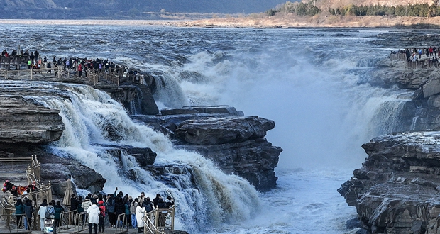 Tourists marvel at the winter splendor of Hukou Waterfall