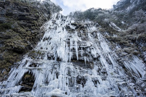 Ice columns form as waterfall freezes mid-flow on Guizhou cliff